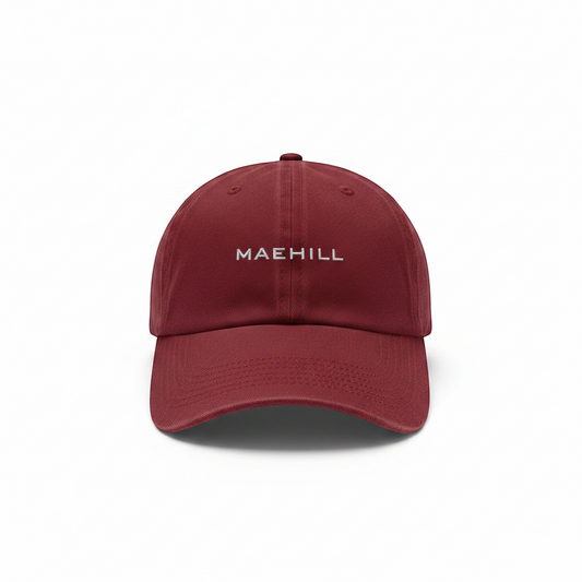 MAEHILL burgundy cotton twill baseball cap with white embroidered logo and curved brim on a white background